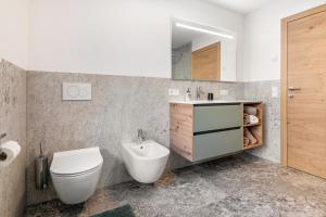a bathroom with a toilet and a sink and a mirror at Pixnerhof - Ferienwohnung Golden in Kastelbell-Tschars +25 photos