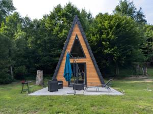 a small cabin with a peaked roof with a person in it at Le petit Sabotier in Soucht