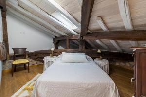 a bedroom with a white bed and two tables at Casa Velarde Apto 2 in Viérnoles