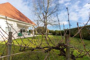 a fence in front of a house with a tree at Chambre d'hotes à Laroin in Laroin