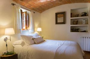 a bedroom with a white bed and a window at Can Bonet - la Volta in Sant Martí Vell +15 photos