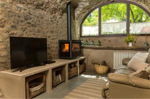 a living room with a tv and a fireplace at Can Bonet - la Volta in Sant Martí Vell