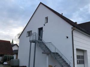 a white building with a staircase on the side at Good Habits in Kleinengstingen