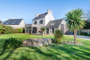 a large house with a palm tree in the yard at Ker Helo-ana in Brignogan-Plage
