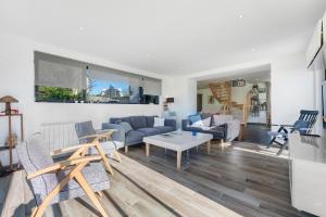 a living room with blue couches and a table at Ker Helo-ana in Brignogan-Plage