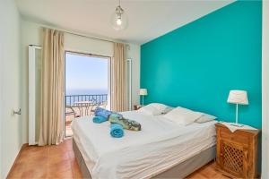 a bedroom with a large bed with a blue wall at Stunning sea views pool garden in La Herradura