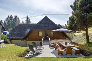 a house with a table and chairs and an umbrella at Ferienhaus Hensler in Hinterzarten