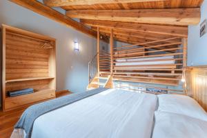 a bedroom with a bed with wooden walls and wooden floors at Civico 8 in Marmora +6 photos