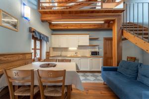 a kitchen and living room with a table and a blue couch at Civico 8 in Marmora