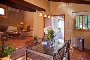 a living room with a glass table with flowers on it at Villa Magdalena in Calvià