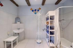 a white bathroom with a shower and a sink at Das Künstlerhaus - dein Sommerhaus in Köckern +18 photos