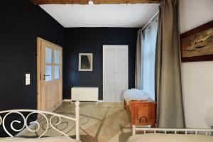 a bedroom with black walls and a bed and a window at Das Künstlerhaus - dein Sommerhaus in Köckern