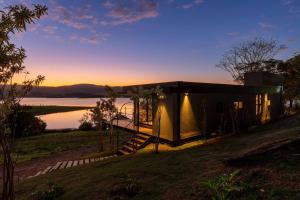 a small house on the shore of a lake at Morro Redondo - Bangalôs com vista do lago e da serra in CÃ¡ssia