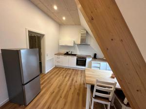 a kitchen with a stainless steel refrigerator and a table at Ferienwohnung Derday im Schuttertal in Schuttertal +5 photos