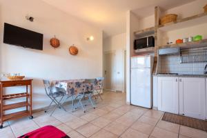 a kitchen with a refrigerator and a table and chairs at Pergola 706 in Stintino