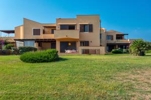 a house with a lawn in front of it at Pergola 706 in Stintino