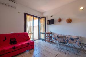 a living room with a red couch and a table at Pergola 706 in Stintino