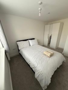 a white bedroom with a large white bed in it at Dzingai Home in Newport