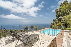 a patio with chairs and a swimming pool at Casa Juliana Tijarafe in Tijarafe