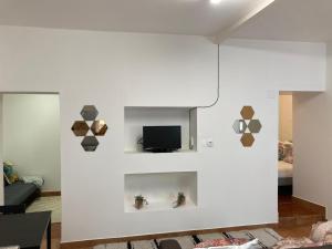 a living room with a tv on a white wall at O Meu Cantinho in Elvas