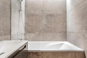 a bathroom with a white tub and a shower at Exception Maison pieds dans l'eau in Fréjus +22 photos