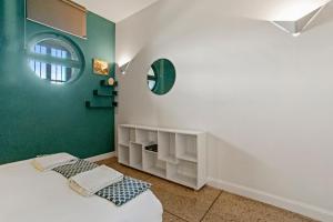 a bedroom with green walls and a bed with a mirror at Exception Maison pieds dans l'eau in Fréjus