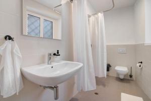 a white bathroom with a sink and a toilet at Workation Castle - Casa Galbiga in Carlazzo