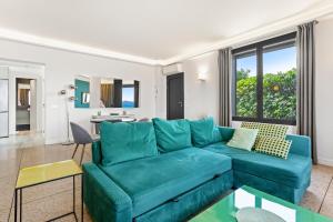 a living room with a blue couch and a table at Exception Maison pieds dans l'eau in Fréjus