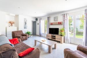 a living room with a couch and a tv at Villa de Maithe, clim, terrasse in Sernhac