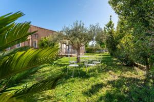 a garden with tables and chairs and trees at Villa de Maithe, clim, terrasse in Sernhac
