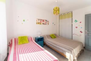 two beds sitting next to each other in a bedroom at Villa de Maithe, clim, terrasse in Sernhac