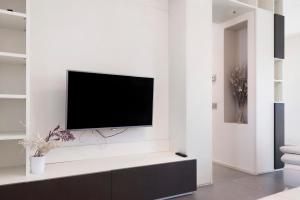 a living room with a tv on a white wall at Villa Luna Al Lago in Biandronno