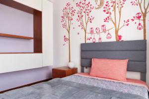 a bedroom with a bed with a gray headboard at Villa Luna Al Lago in Biandronno