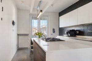a kitchen with white cabinets and a stove top oven at Villa Luna Al Lago in Biandronno