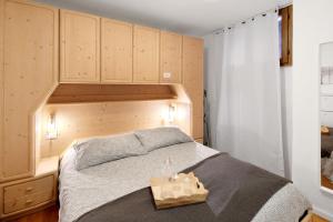 a bedroom with a bed with a wooden headboard at Ciasa de Lucky in Moena