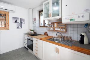 a kitchen with white cabinets and a sink at Ciasa de Lucky in Moena