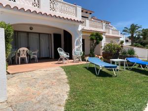 a house with a patio with chairs and a table at Villetta Son Bou in Son Bou