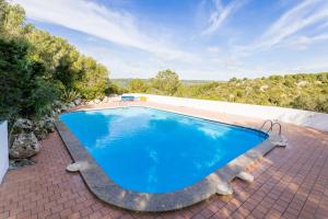 a large swimming pool on a brick patio at Villetta Son Bou in Son Bou