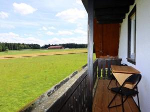 a porch with a table and chairs and a field at Ferienwohnung Beim Falkner, 60qm in Königsfeld im Schwarzwald