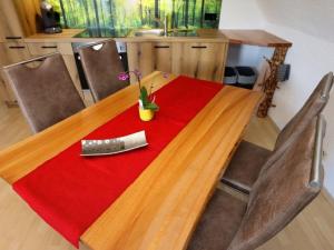 a wooden table with a red table cloth and a knife at Ferienwohnung Beim Falkner, 60qm in Königsfeld im Schwarzwald +6 photos