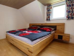a bedroom with a wooden bed with a window at Ferienwohnung Beim Falkner, 60qm in Königsfeld im Schwarzwald