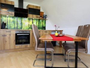 a kitchen with a wooden table and chairs at Ferienwohnung Beim Falkner, 60qm in Königsfeld im Schwarzwald