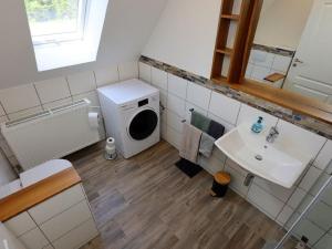 a bathroom with a washing machine and a sink at Ferienwohnung Beim Falkner, 60qm in Königsfeld im Schwarzwald