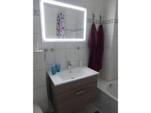 a bathroom with a sink and a mirror and a tub at Ferienwohnung Seepferdchen in Heiligenhafen +23 photos
