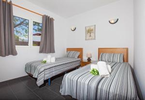 a bedroom with two beds and a window at Villa Esencia in Puerto del Carmen