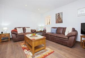 a living room with two couches and a tv at Villa Esencia in Puerto del Carmen