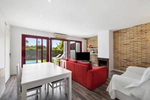 a living room with a red couch and a table at Casa-piscina privada en Vallpineda in Sant Pere de Ribes