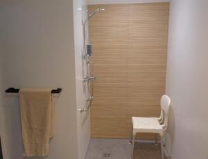 a shower with a white chair in a bathroom at Studio L'Erdre au moulin - terrasse in Joué-sur-Erdre