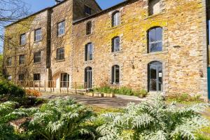an old brick building with a garden in front of it at Studio L'Erdre au moulin - terrasse in Joué-sur-Erdre +3 photos