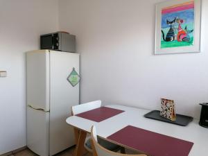 a kitchen with a white table and a refrigerator at Ferienwohnung Kirsch-Kern in Mössingen